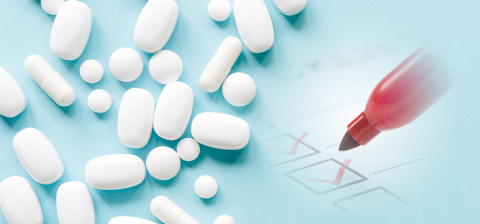 photo illustration with white pills on a light blue background with checkboxes and red marker